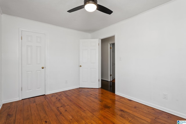 unfurnished bedroom with hardwood / wood-style floors, crown molding, a ceiling fan, and baseboards