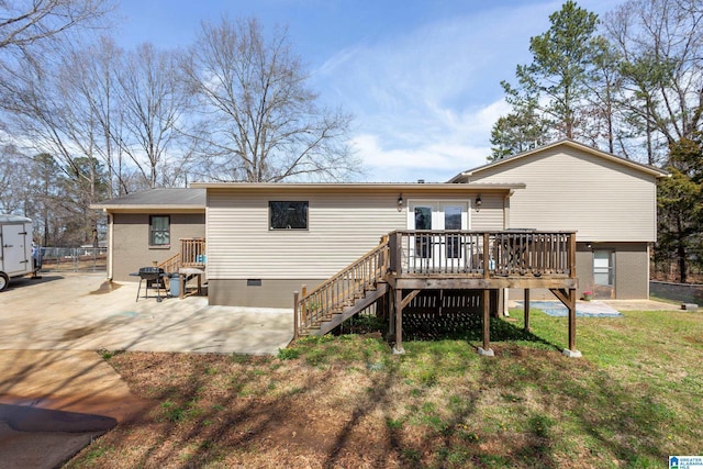 rear view of house featuring french doors, a yard, a wooden deck, brick siding, and a patio area