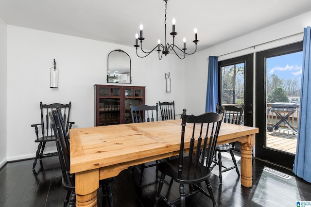 dining area featuring visible vents, baseboards, dark wood-type flooring, and an inviting chandelier