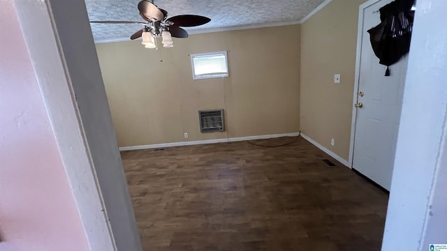 spare room with ornamental molding, heating unit, a textured ceiling, baseboards, and ceiling fan