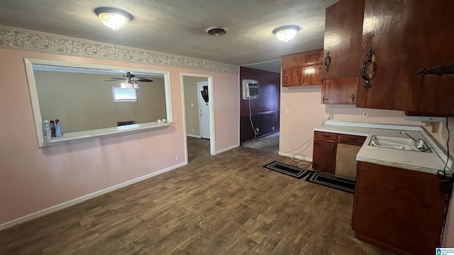 kitchen with baseboards, visible vents, dark wood-style flooring, a sink, and light countertops