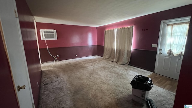 foyer entrance featuring carpet flooring and a wall unit AC