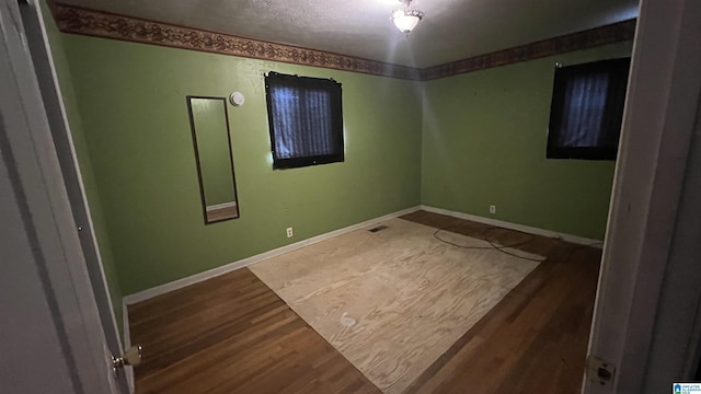 unfurnished room featuring baseboards and wood finished floors