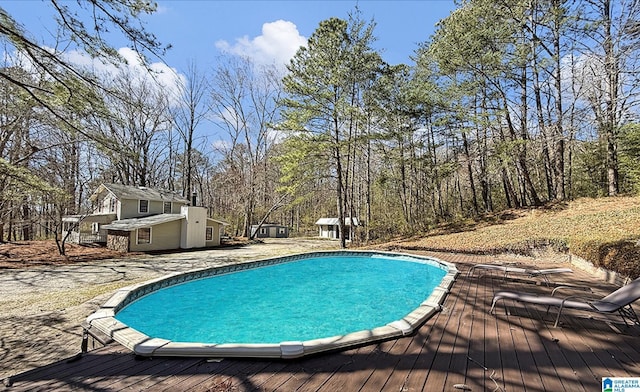 pool featuring an outdoor structure and a deck