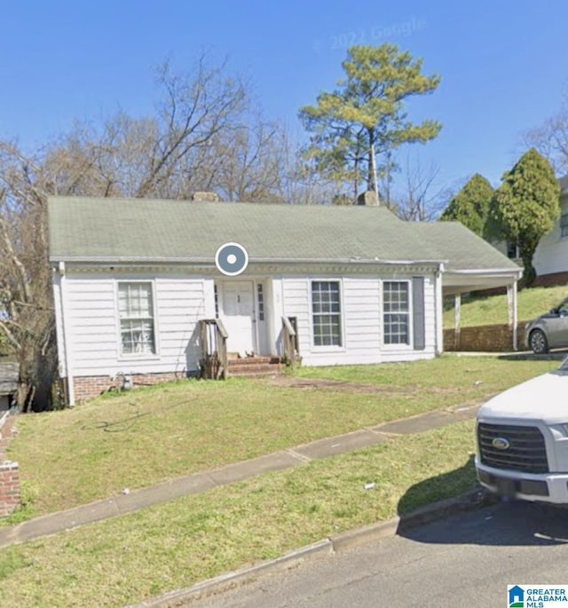 ranch-style house featuring a front yard and a carport