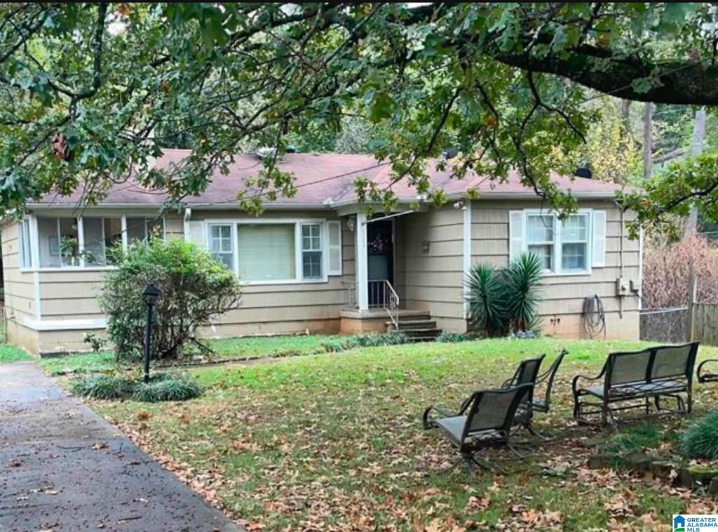 ranch-style house with a front yard and fence