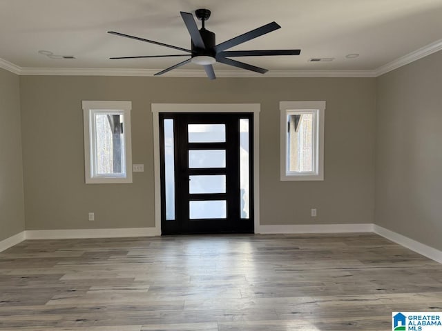 foyer entrance with baseboards, wood finished floors, visible vents, and ornamental molding