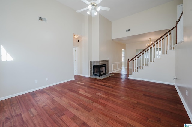 unfurnished living room with visible vents, stairs, baseboards, and wood finished floors