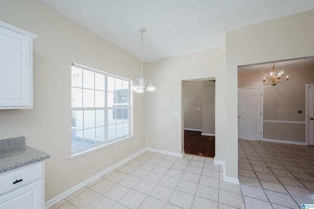 unfurnished dining area featuring an inviting chandelier, light tile patterned flooring, baseboards, and vaulted ceiling