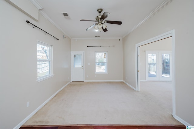 spare room featuring crown molding, light colored carpet, visible vents, and baseboards