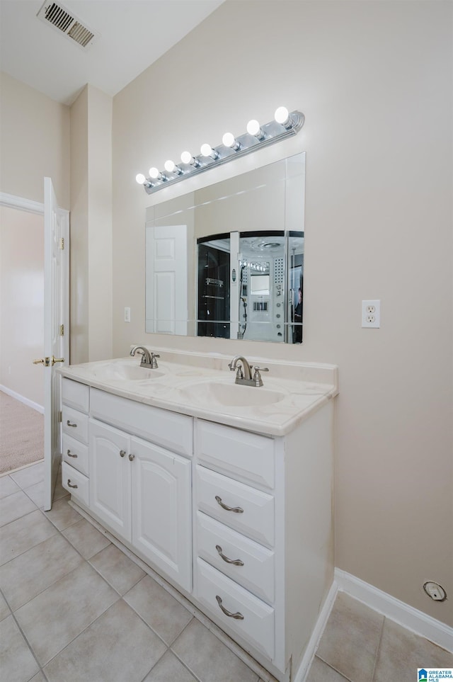 bathroom with double vanity, visible vents, tile patterned floors, and a sink