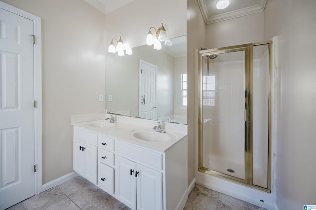 bathroom featuring double vanity, a stall shower, crown molding, and a sink