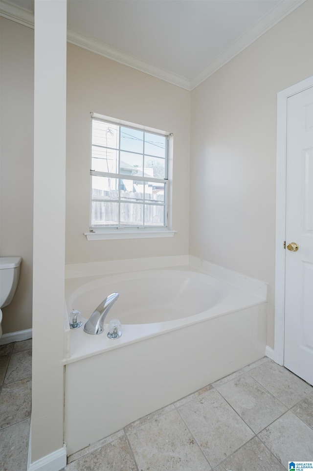 full bathroom featuring a garden tub, toilet, baseboards, and ornamental molding