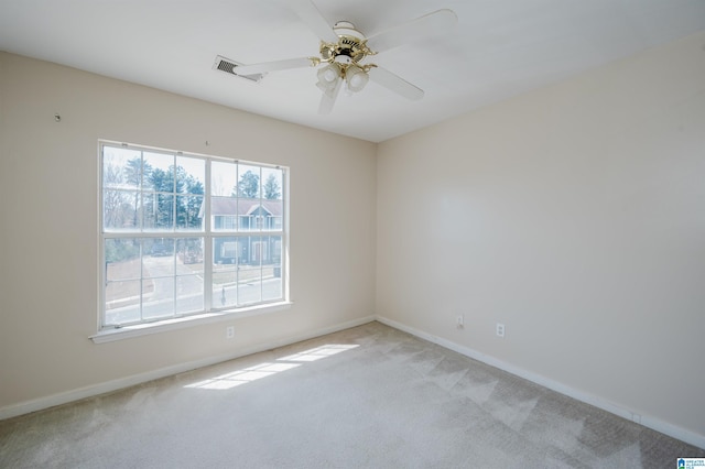 spare room featuring visible vents, baseboards, light colored carpet, and ceiling fan