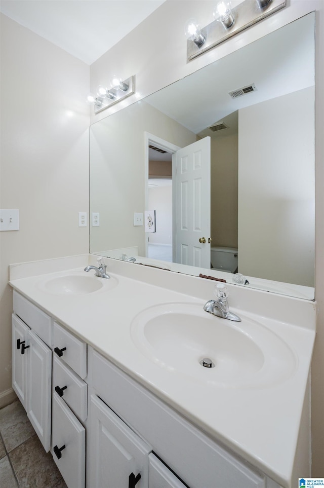 bathroom with a sink, visible vents, toilet, and double vanity