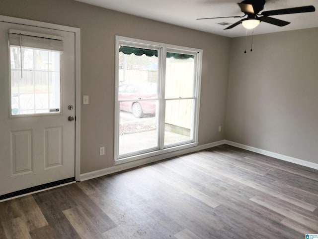 doorway to outside featuring visible vents, wood finished floors, baseboards, and ceiling fan