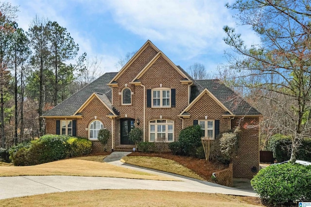 view of front of house featuring brick siding and a front lawn