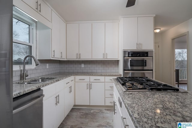 kitchen featuring a wealth of natural light, decorative backsplash, stainless steel appliances, and a sink