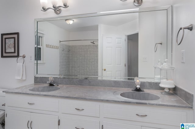 full bath featuring double vanity, toilet, a shower, and a sink