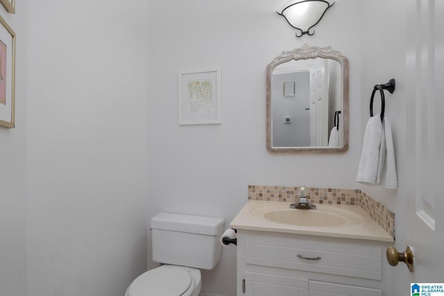 half bathroom with tasteful backsplash, vanity, and toilet