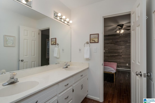 ensuite bathroom featuring double vanity, ensuite bath, a ceiling fan, and a sink