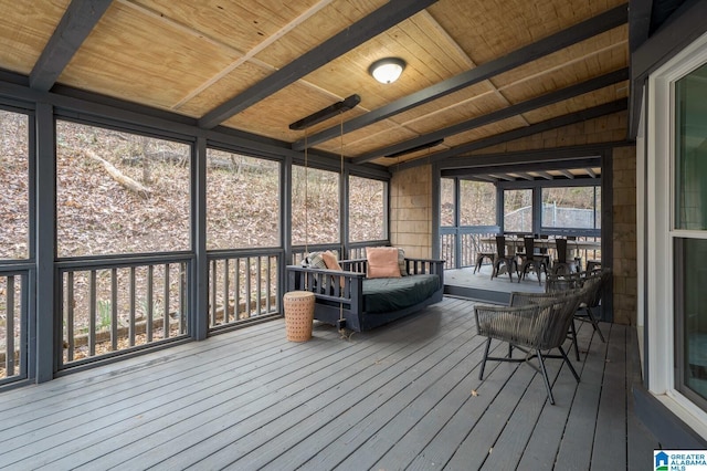 unfurnished sunroom featuring lofted ceiling with beams, wood ceiling, and a healthy amount of sunlight