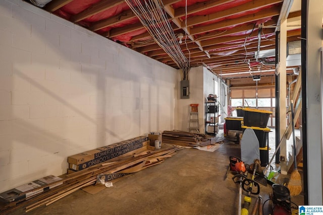 basement featuring electric panel and concrete block wall