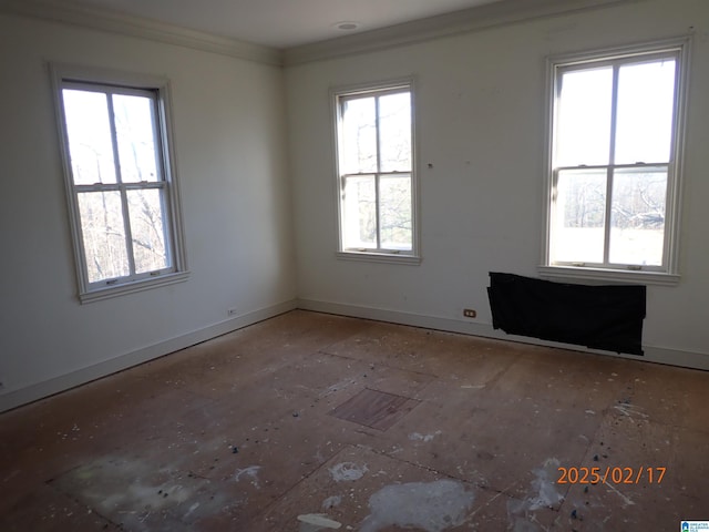 unfurnished room featuring baseboards and crown molding