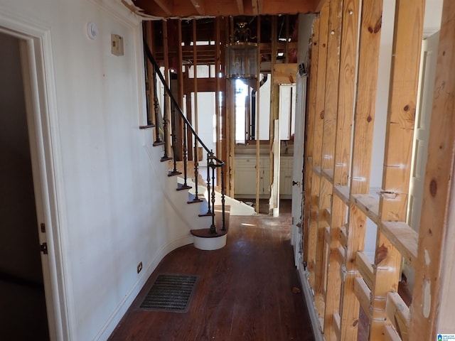 corridor featuring stairs, wood finished floors, visible vents, and baseboards