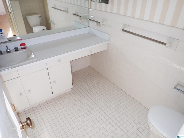 bathroom with vanity, toilet, and tile walls