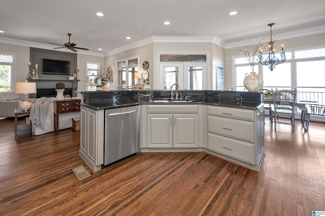 kitchen featuring visible vents, a fireplace, a sink, stainless steel dishwasher, and open floor plan