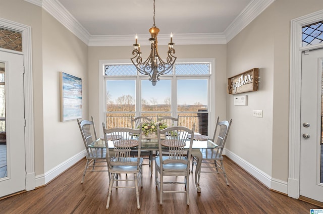 dining room featuring baseboards, an inviting chandelier, wood finished floors, and crown molding