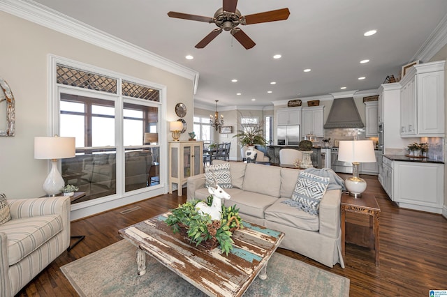 living area with dark wood-style floors, recessed lighting, ceiling fan with notable chandelier, and ornamental molding