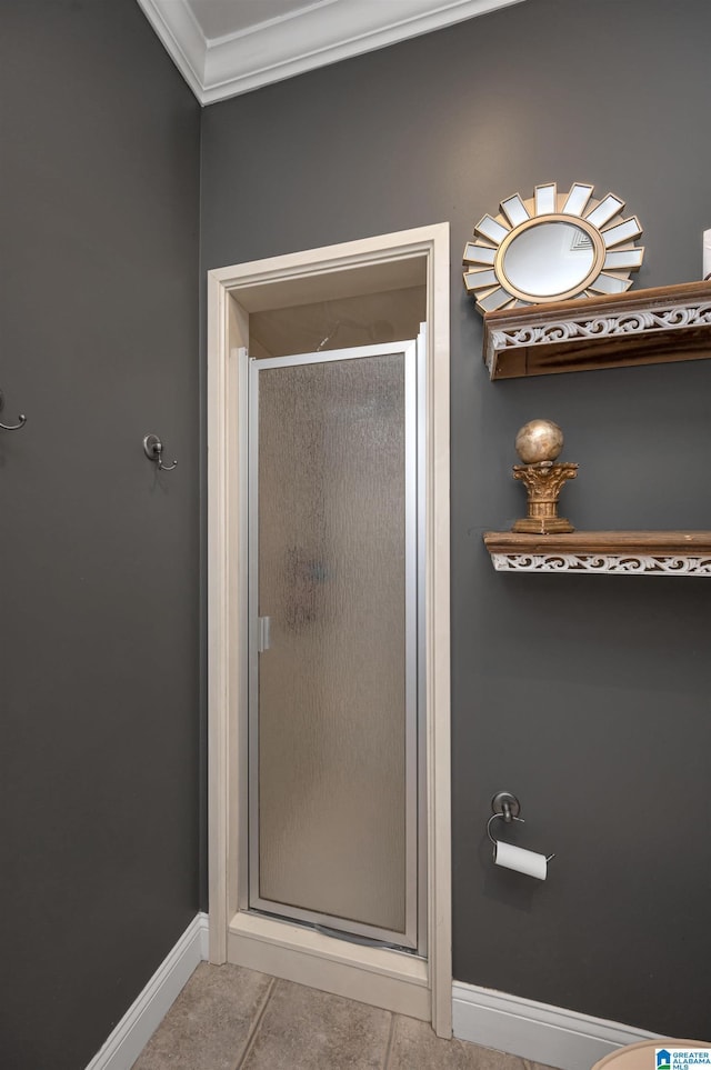 bathroom featuring tile patterned floors, baseboards, a shower stall, and crown molding