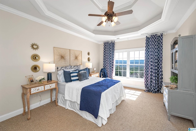 bedroom with a raised ceiling, crown molding, carpet, and baseboards