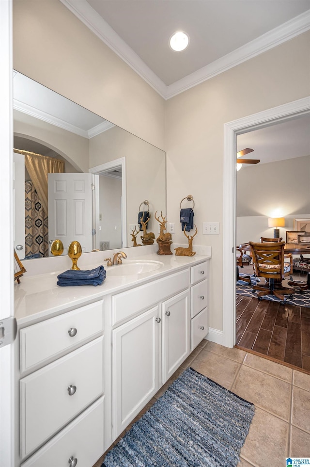 bathroom with vanity, crown molding, and baseboards