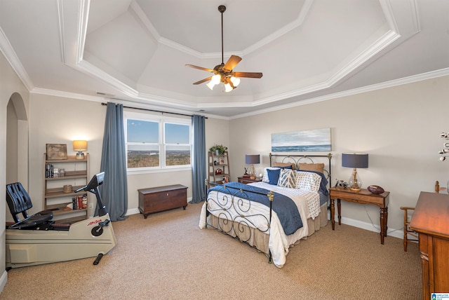 bedroom with a raised ceiling, carpet flooring, crown molding, and arched walkways