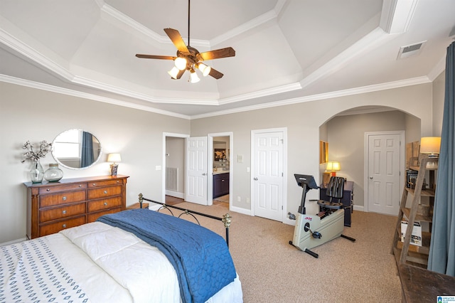 bedroom featuring visible vents, baseboards, light carpet, arched walkways, and a raised ceiling