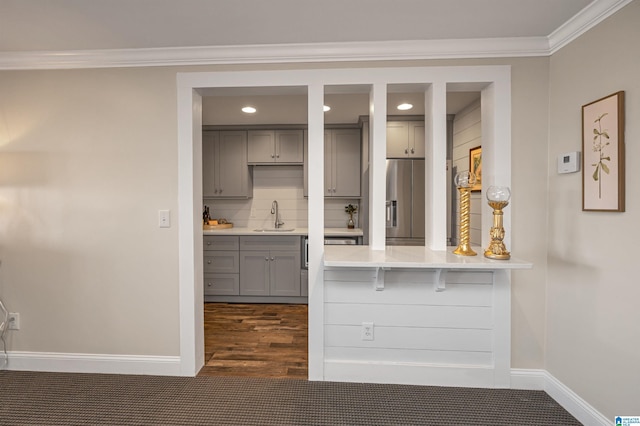 interior space featuring gray cabinets, a sink, light countertops, tasteful backsplash, and stainless steel fridge