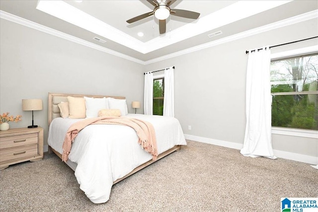 carpeted bedroom featuring visible vents, baseboards, a tray ceiling, and ornamental molding