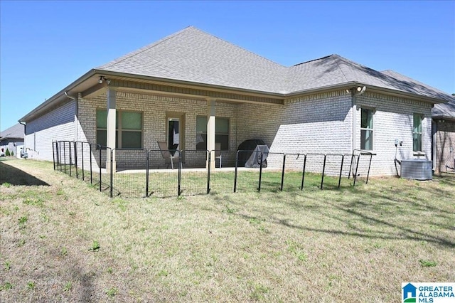 view of home's exterior with brick siding, central AC unit, a yard, and roof with shingles