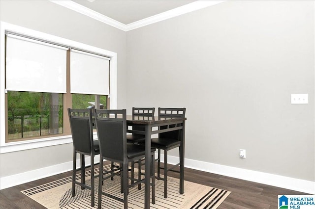 dining space with baseboards, wood finished floors, and crown molding