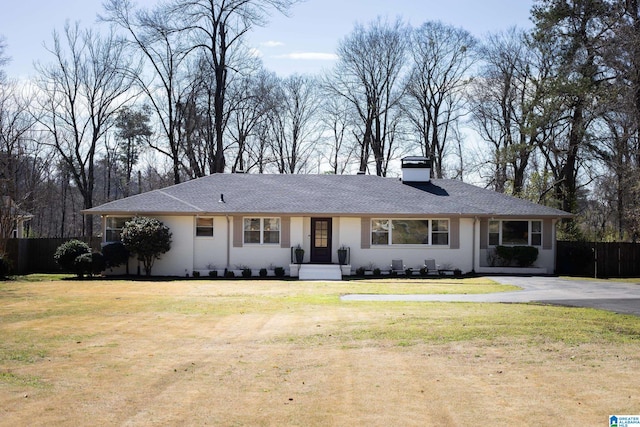 ranch-style house featuring a front yard, fence, and a chimney