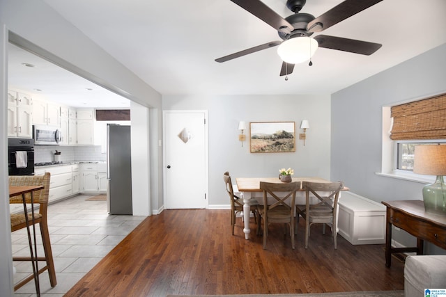 dining room featuring baseboards, wood finished floors, and ceiling fan