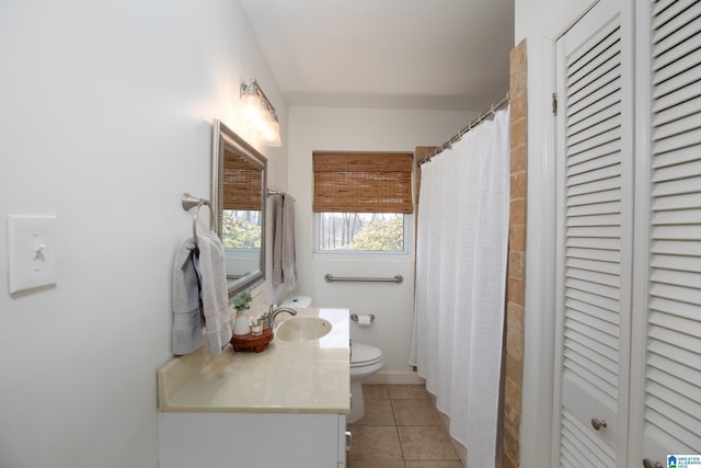 bathroom with tile patterned flooring, toilet, vanity, and a closet