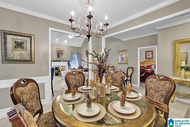 dining room with ornamental molding, wainscoting, and a chandelier