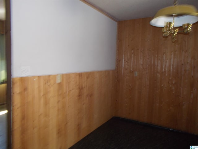 empty room featuring wooden walls and wainscoting