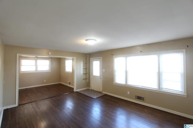 foyer entrance featuring visible vents, baseboards, and wood finished floors