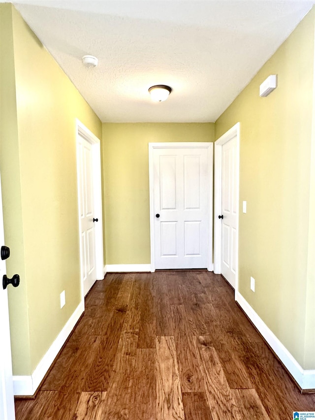 hallway with wood finished floors and baseboards