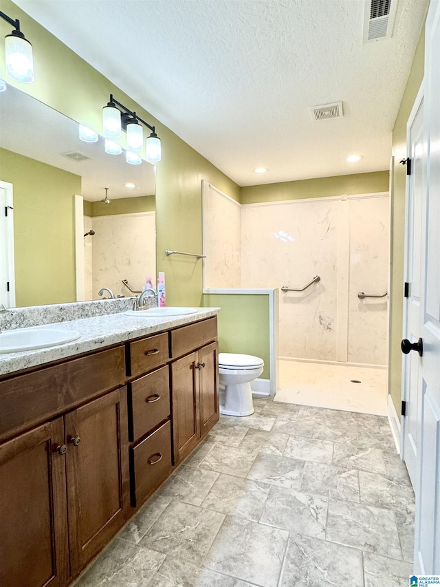 bathroom featuring visible vents, walk in shower, and a sink